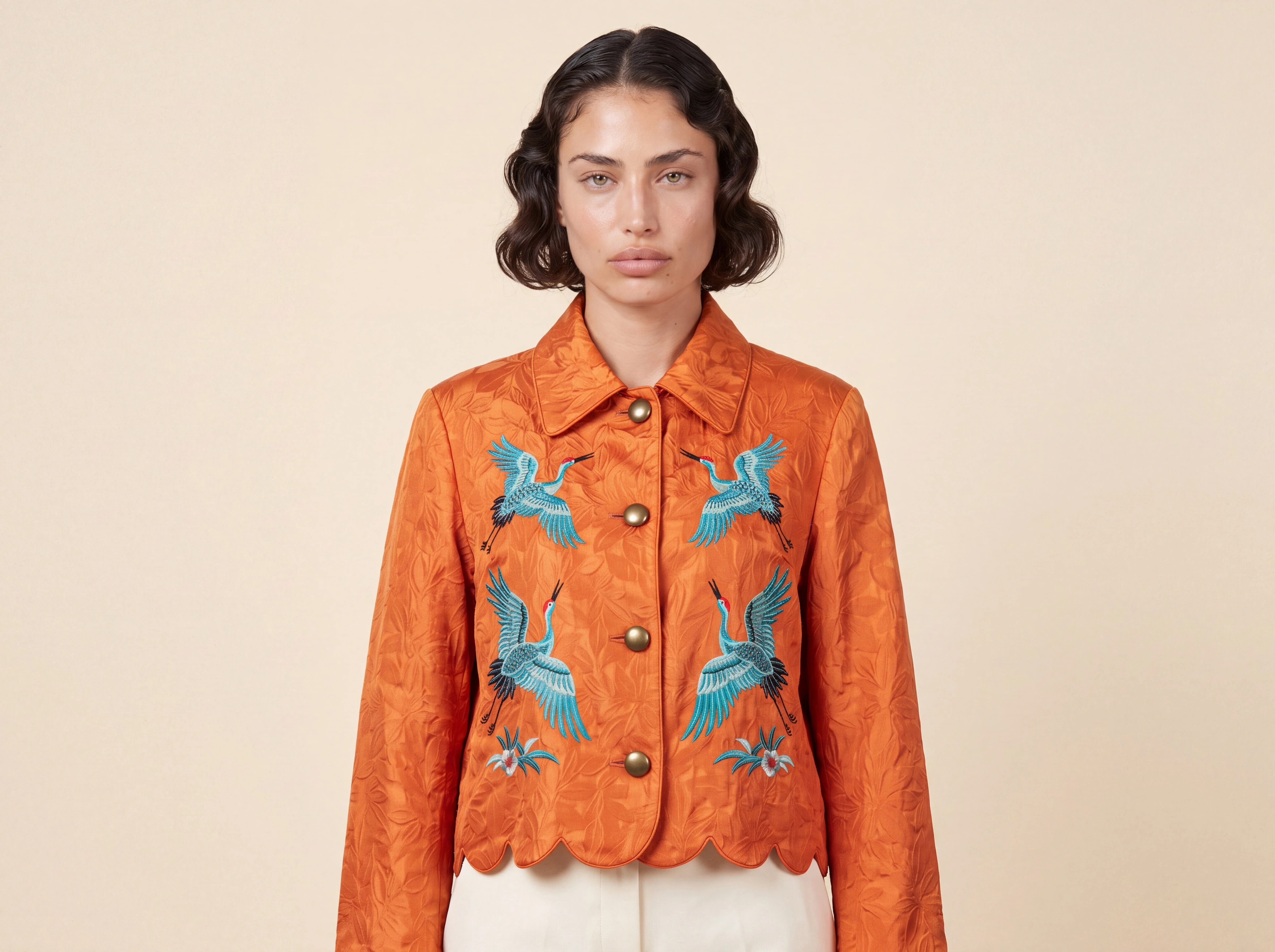 Nano Banana 2.1 portrait of a synthetic model wearing an orange crane-embroidered jacket