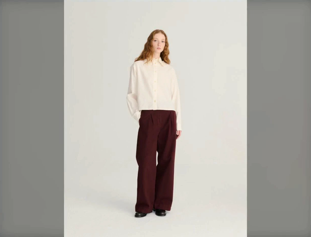 Full-length Bobo Choses photograph showing the cream shirt, burgundy trousers and flat shoes