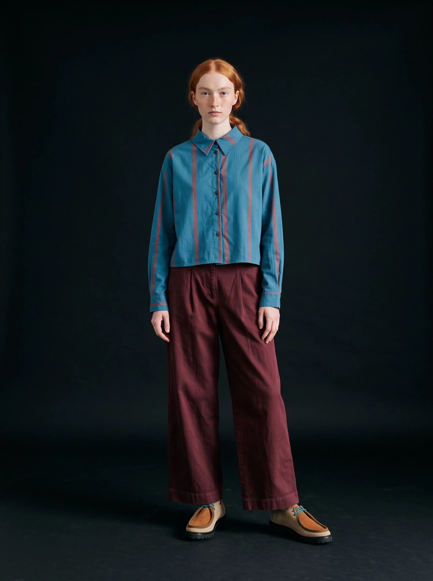 Reference-based result of the blue striped shirt against a dark photographic background